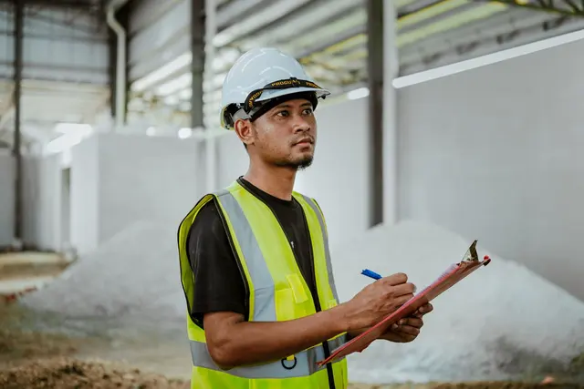 A workplace supervisor reviewing inspection records on a clipboard